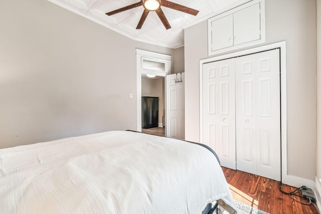 bedroom featuring wood-type flooring, ceiling fan, and a closet