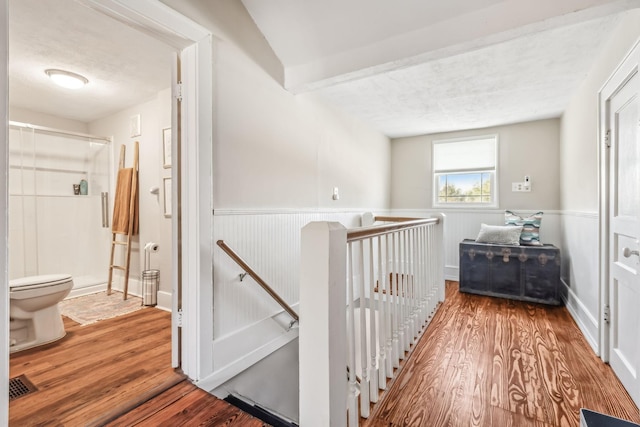 hallway with wood-type flooring and a textured ceiling