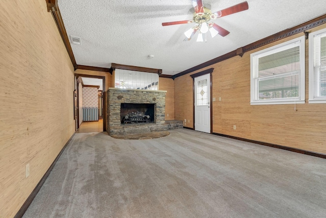 unfurnished living room featuring ornamental molding, light colored carpet, and a textured ceiling