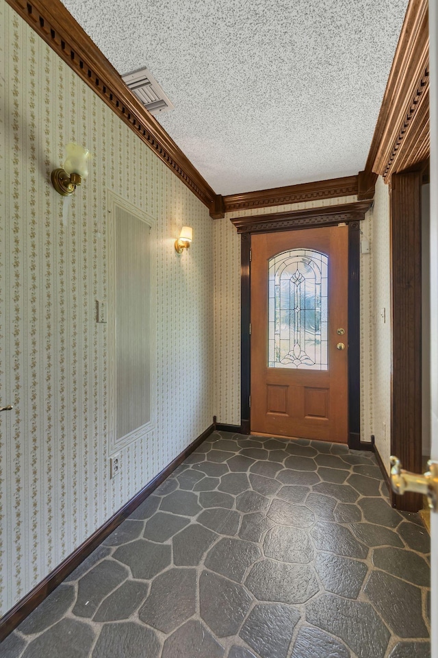 foyer entrance with crown molding and a textured ceiling