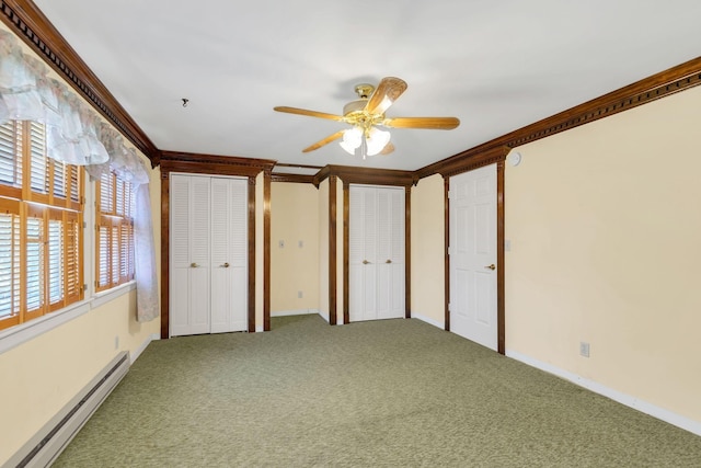 unfurnished bedroom with a baseboard heating unit, two closets, carpet floors, and ornamental molding