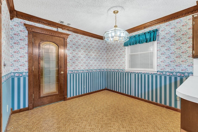 empty room with a notable chandelier, crown molding, and a textured ceiling