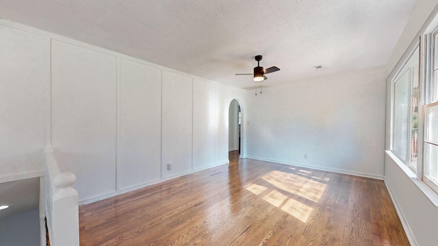 unfurnished room with ceiling fan, hardwood / wood-style floors, and a textured ceiling