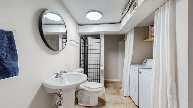 bathroom featuring independent washer and dryer and toilet