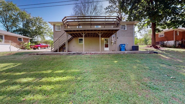 rear view of property with central AC, a yard, and a wooden deck