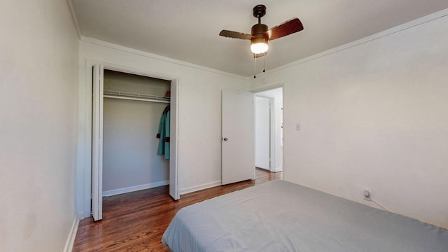 bedroom with crown molding, ceiling fan, dark hardwood / wood-style flooring, and a closet