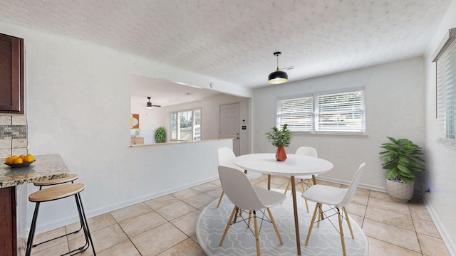 tiled dining area featuring a healthy amount of sunlight and a textured ceiling