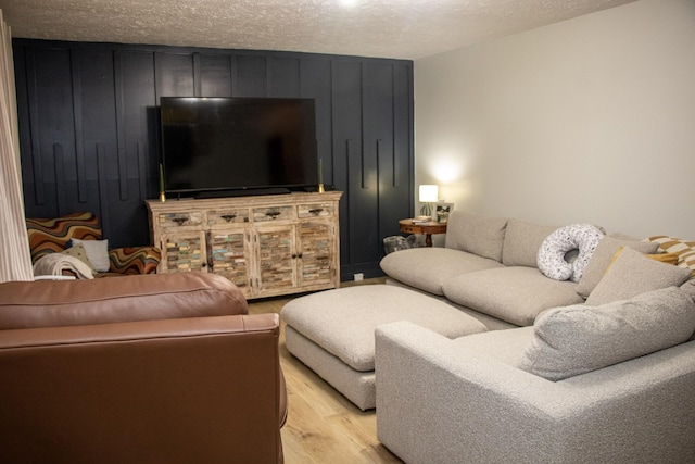 living room with a textured ceiling and light wood-type flooring