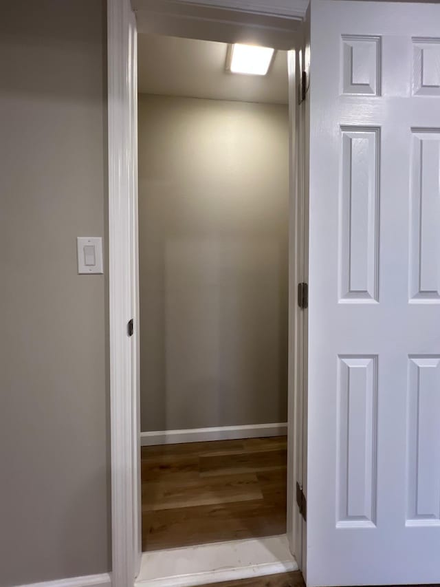 interior space featuring baseboards and wood finished floors