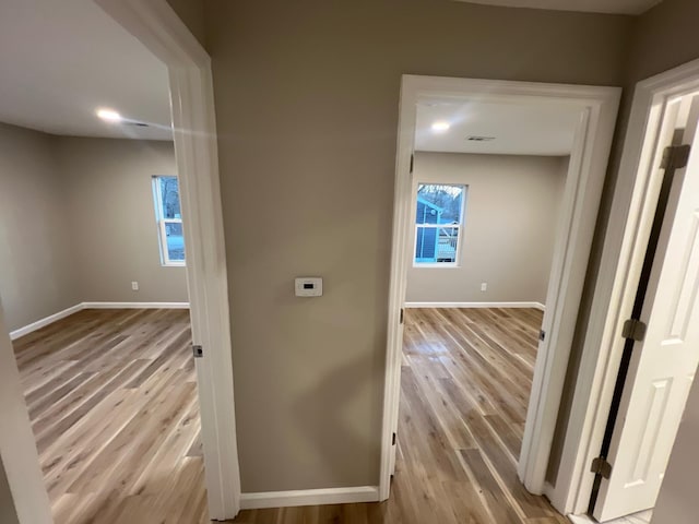 corridor with baseboards and wood finished floors