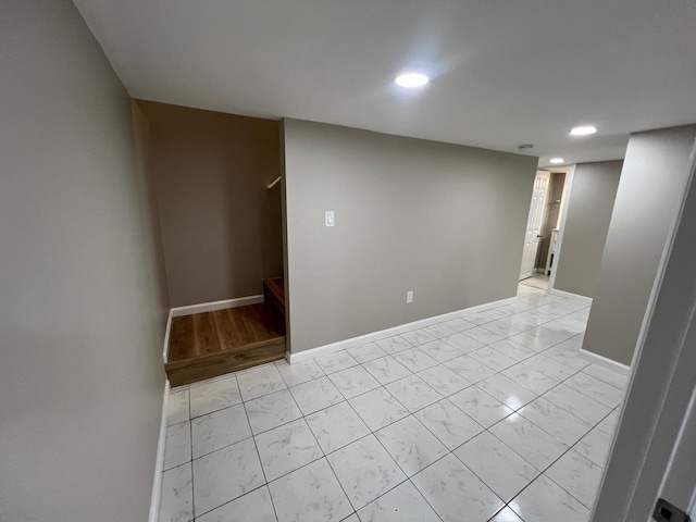 unfurnished room with recessed lighting, baseboards, marble finish floor, and stairs