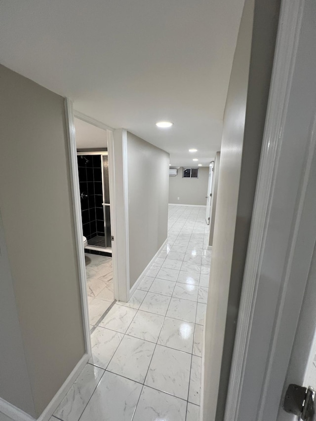 hallway with visible vents, baseboards, and marble finish floor