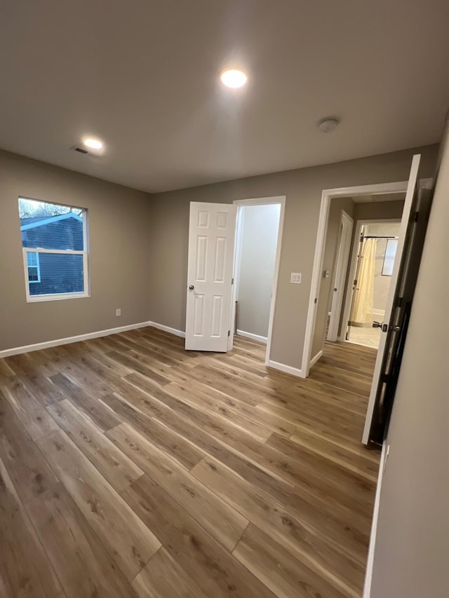 unfurnished bedroom with recessed lighting, visible vents, baseboards, and wood finished floors