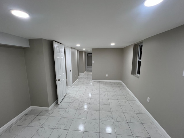 finished basement with recessed lighting, marble finish floor, and baseboards