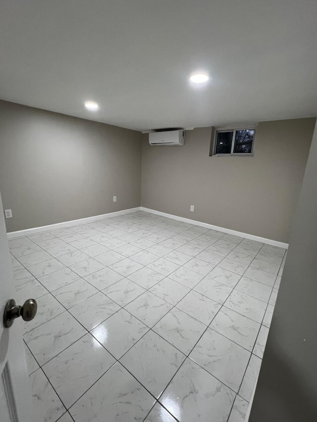 finished basement with a wall mounted air conditioner, baseboards, marble finish floor, and recessed lighting