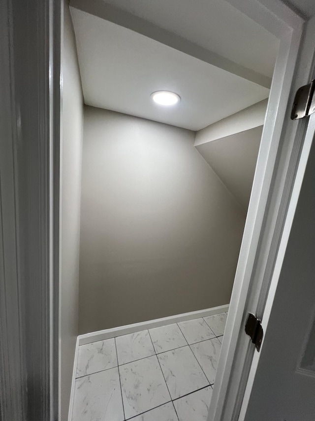 interior space featuring baseboards and marble finish floor