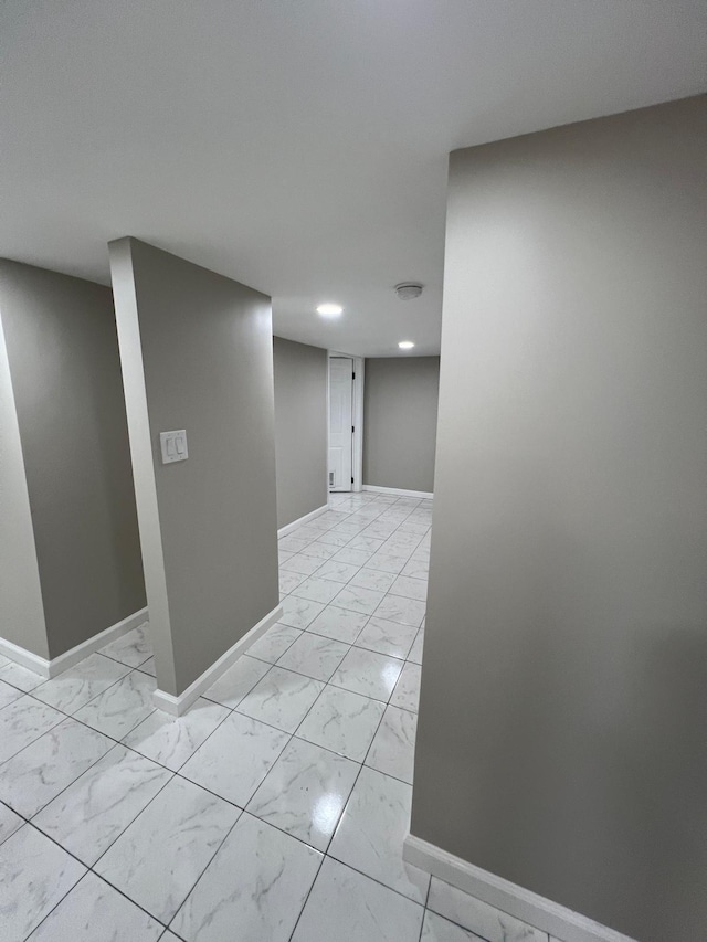 corridor with baseboards and marble finish floor