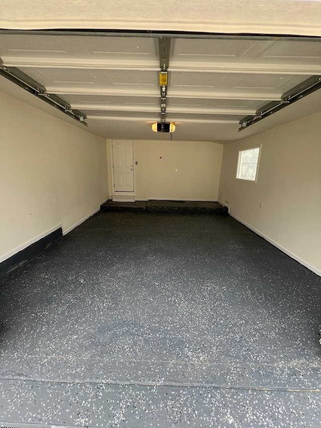 garage with a garage door opener and baseboards