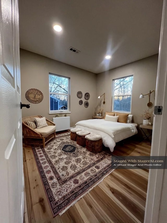 bedroom featuring recessed lighting, visible vents, wood finished floors, and radiator heating unit