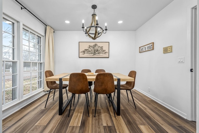 dining space with dark hardwood / wood-style floors and a chandelier