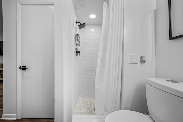 bathroom featuring curtained shower and toilet