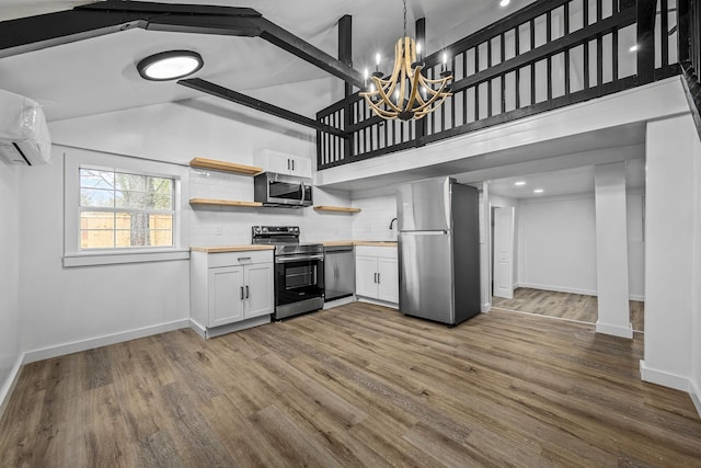 kitchen with appliances with stainless steel finishes, white cabinetry, butcher block counters, tasteful backsplash, and decorative light fixtures