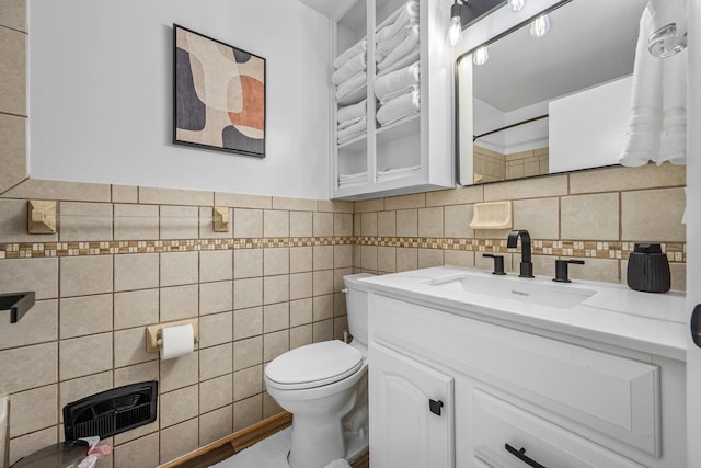 bathroom with vanity, toilet, and tile walls