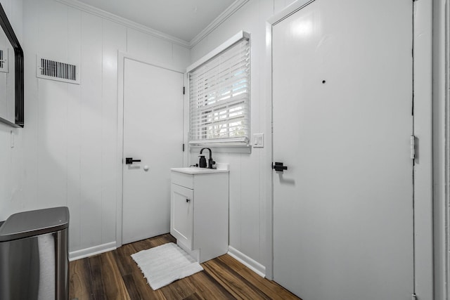 bathroom featuring ornamental molding, wood-type flooring, and vanity