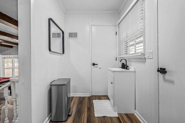 bathroom with crown molding, vanity, hardwood / wood-style flooring, and beamed ceiling