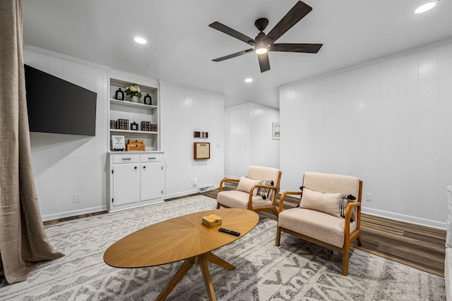 living area with ceiling fan, light wood-type flooring, and built in shelves