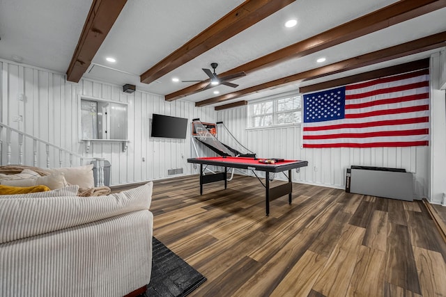 recreation room featuring ceiling fan, dark wood-type flooring, radiator heating unit, and beam ceiling