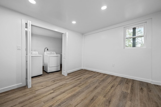 clothes washing area featuring hardwood / wood-style floors and washer and clothes dryer