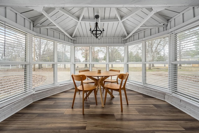 sunroom with lofted ceiling, a wealth of natural light, and a chandelier