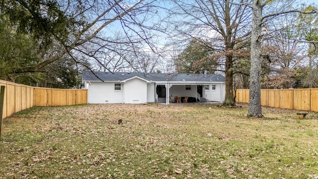 back of property with a lawn and a patio