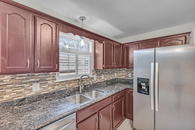 kitchen featuring reddish brown cabinets, appliances with stainless steel finishes, backsplash, and a sink