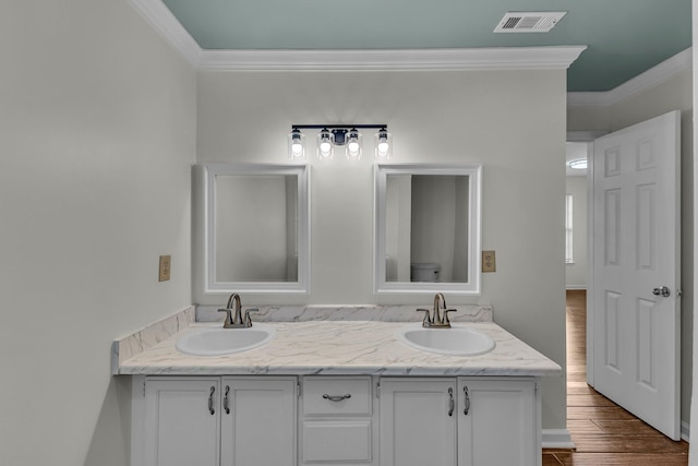 full bath with double vanity, wood finished floors, a sink, and visible vents