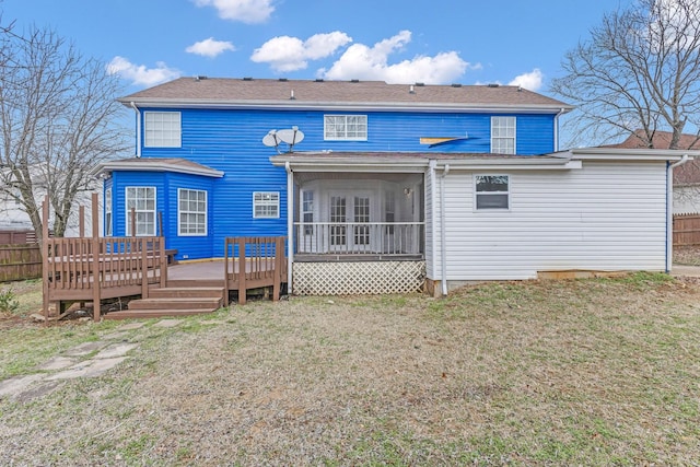 rear view of house with a sunroom, fence, a lawn, and a wooden deck