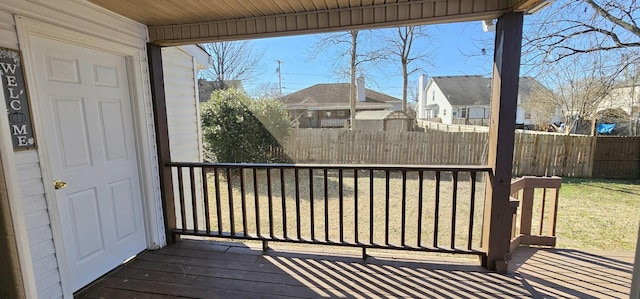 wooden terrace featuring a yard and fence