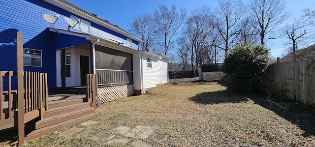 view of yard featuring a storage unit, fence, and an outbuilding