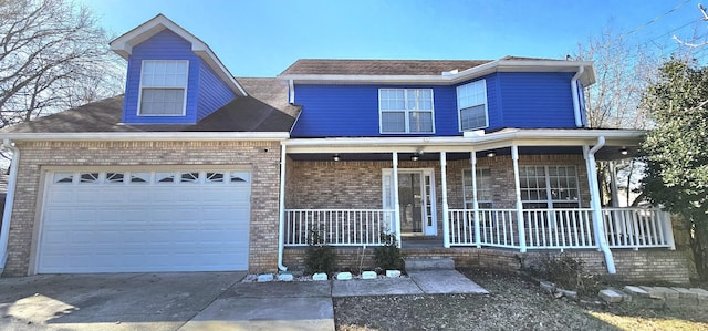 view of front of property with a garage, covered porch, driveway, and brick siding