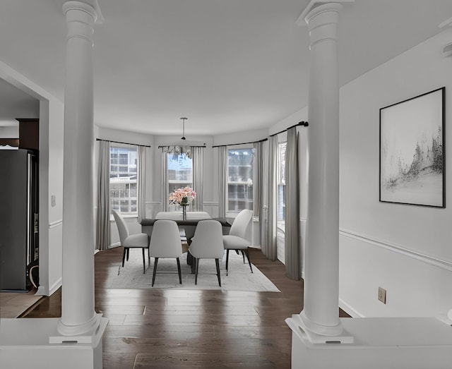 dining area featuring dark wood-style floors and decorative columns