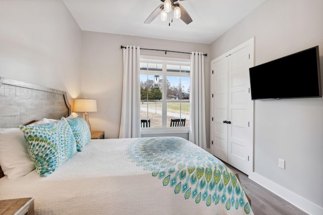 bedroom with ceiling fan, dark hardwood / wood-style flooring, and a closet