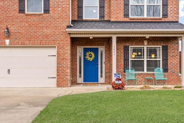 property entrance with a garage and a lawn