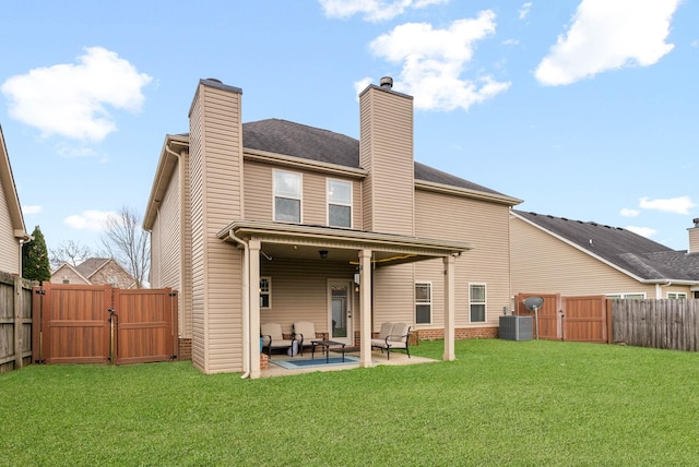 rear view of house with a yard, central AC unit, and a patio area