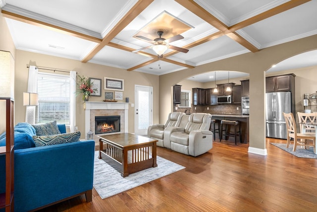 living room featuring coffered ceiling, dark wood-type flooring, a wealth of natural light, and beam ceiling