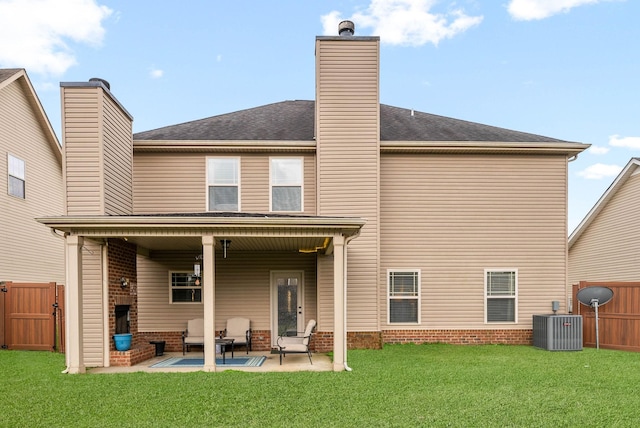 back of house featuring a yard, a fireplace, central AC unit, and a patio area