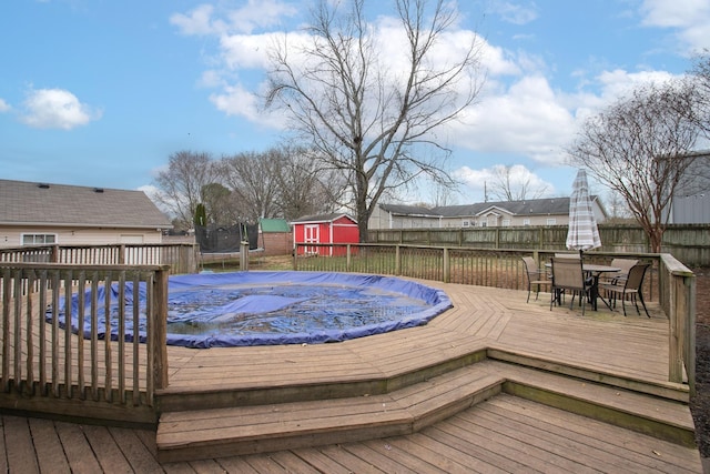 wooden terrace featuring a shed and a trampoline