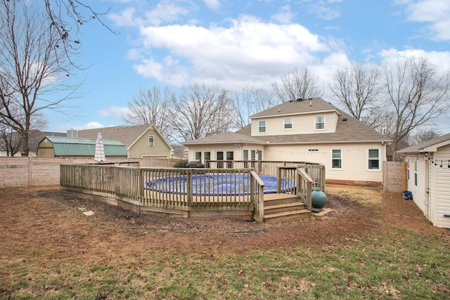 back of property featuring a pool side deck and a yard