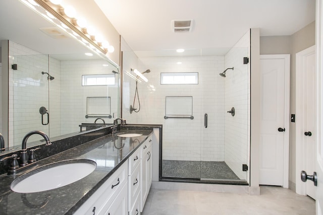 bathroom with walk in shower, tile patterned floors, and vanity