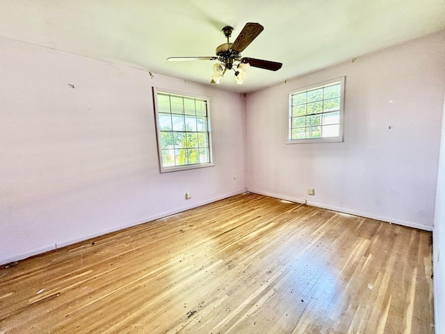 spare room with ceiling fan, light hardwood / wood-style flooring, and a healthy amount of sunlight